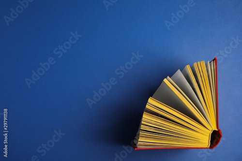 Hardcover book on blue background  top view