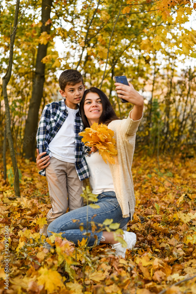 mom and son take selfies in the autumn forest. copy space mom and son take selfies in the autumn forest. copy space
