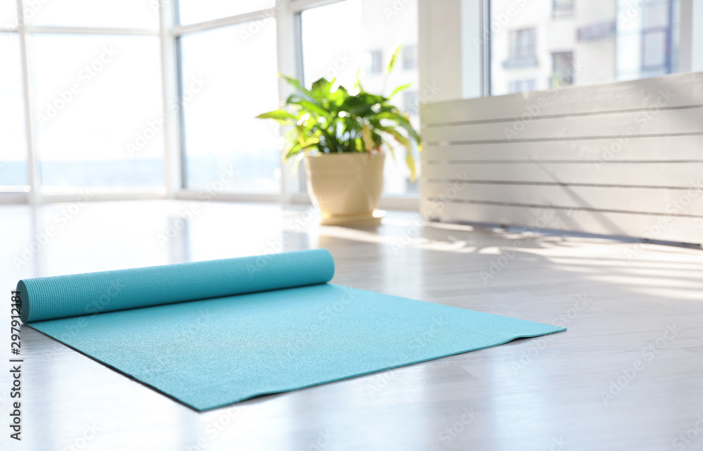 Unrolled light blue yoga mat on floor in room Stock Photo | Adobe Stock