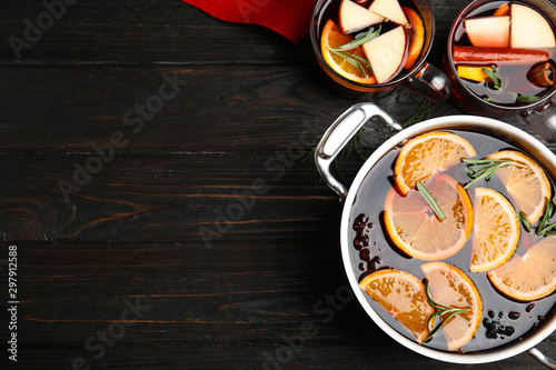 Tasty mulled wine with spices on wooden table, flat lay. Space for text