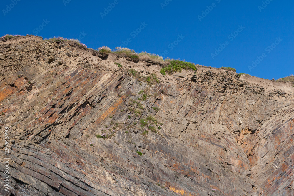 cross section of cliff geology at Weclombe mouth beach in devon, england with blue sky