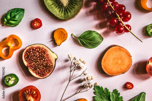 Raw healthy food collage - set of fruits and vegetables on a light pink background