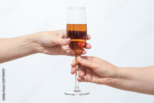 Female hand gives a glass with alcohol to another woman close up.