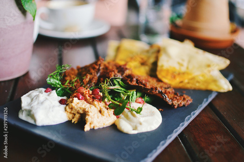 Mediterranean meze with flat bread, hummus, tzatziki, taramasalata and fried eggplant photo