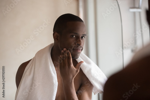 Obraz na plátně Confident african american young man looking in mirror after shower