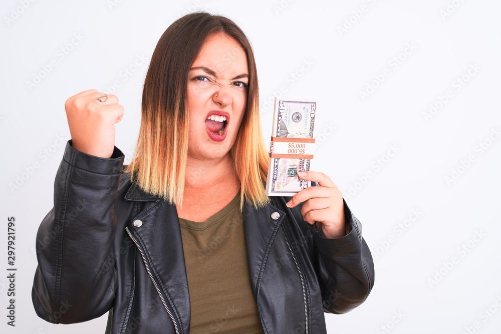 Young beautiful woman holding dollars standing over isolated white background annoyed and frustrated shouting with anger, crazy and yelling with raised hand, anger concept Young beautiful woman holding dollars standing over isolated white background annoyed and frustrated shouting with anger, crazy and yelling with raised hand, anger concept
