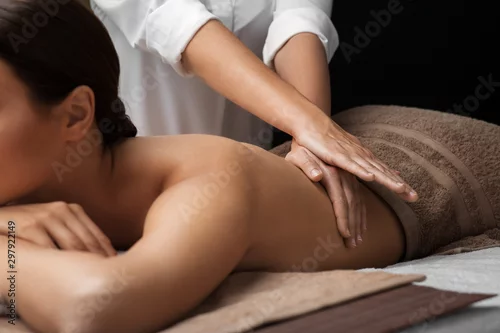 Obraz koncepcja odnowy biologicznej, urody i relaksu - piękna młoda kobieta, leżąc i masaż pleców w spa