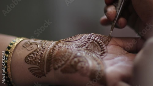 Applying henna to girls hand . The design of the henna can be seen as its shot closeup photo