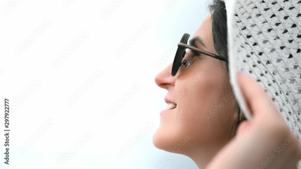 Close-up laughing face of brunette young woman in sunglasses and white hat enjoying freedom Close-up laughing face of brunette young woman in sunglasses and white hat enjoying freedom