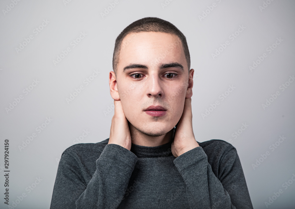 Fototapeta premium Feared unhappy crying man with shocked face with headache holding the head. Closeup studio portrait on grey background. Negative problem