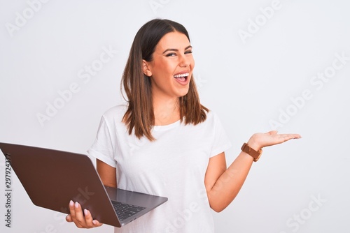 Beautiful young woman working using computer laptop over white background pointing aside with hands open palms showing copy space, presenting advertisement smiling excited happy