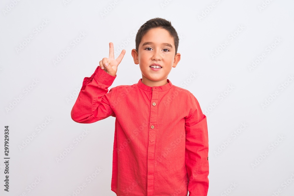 Beautiful kid boy wearing elegant red shirt standing over isolated white background showing and pointing up with fingers number two while smiling confident and happy.