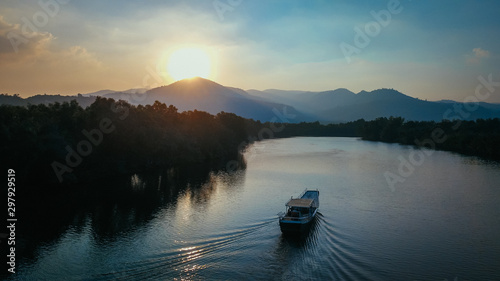 Beautiful Drone Shot of a Boat on the Prek Kampot River at Sunset during a River Cruise in Kampot, Cambodia. photo
