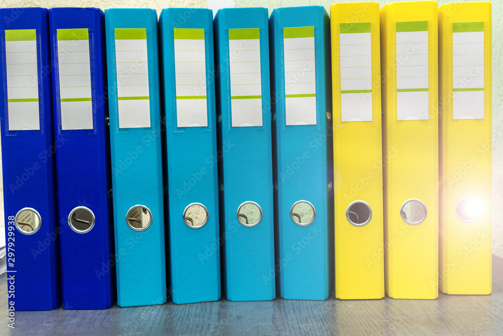 Row from the blue yellow file folders with clean blank for your text. Large stationery folders, paperwork abstract background Row from the blue yellow file folders with clean blank for your text. Large stationery folders, paperwork abstract background