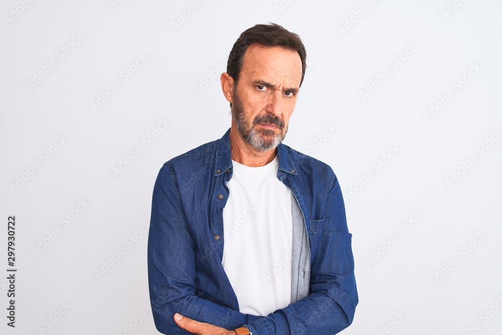 Middle age handsome man wearing blue denim shirt standing over isolated white background skeptic and nervous, frowning upset because of problem. Negative person. Middle age handsome man wearing blue denim shirt standing over isolated white background skeptic and nervous, frowning upset because of problem. Negative person.