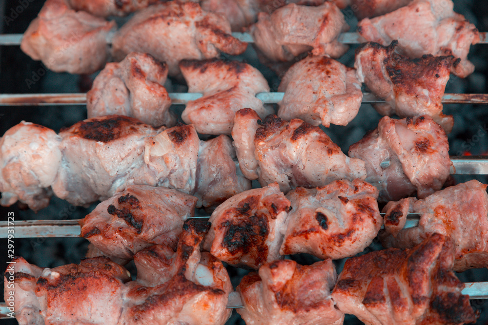 Close-up Shish kebab on skewers and hot coals with smoke.