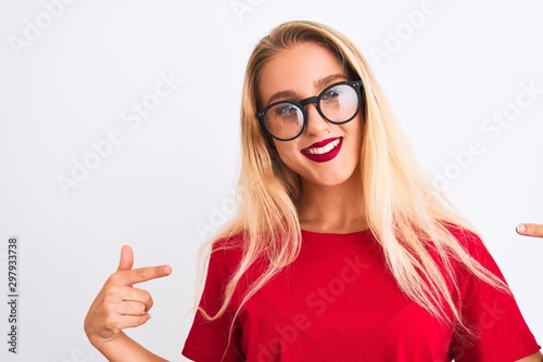 Young beautiful woman wearing red t-shirt and glasses standing over isolated white background looking confident with smile on face  pointing oneself with fingers proud and happy.