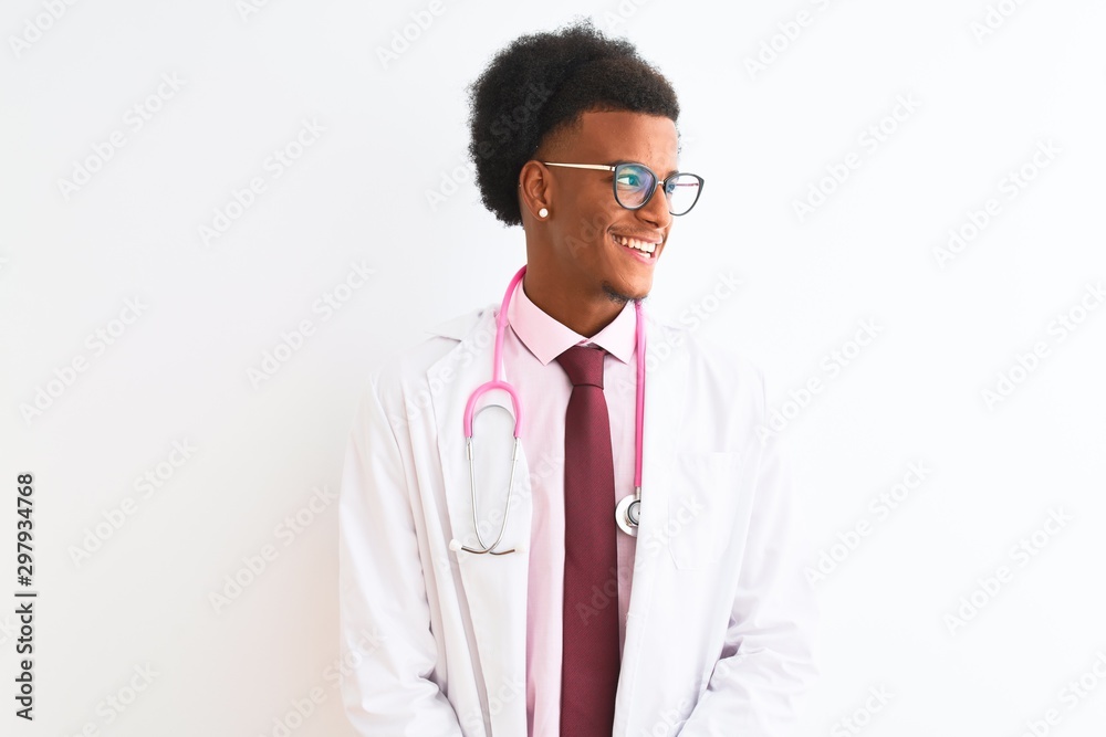 Young african american doctor man wearing pink stethoscope over isolated white background looking away to side with smile on face, natural expression. Laughing confident. Young african american doctor man wearing pink stethoscope over isolated white background looking away to side with smile on face, natural expression. Laughing confident.