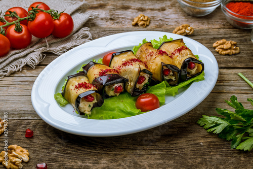 Eggplant rolls stuffed with nuts on wooden table
