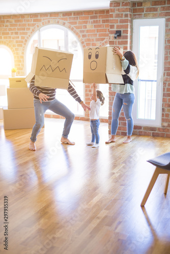 Beautiful famiily with kid playing with cardboard fanny boxes at new home photo