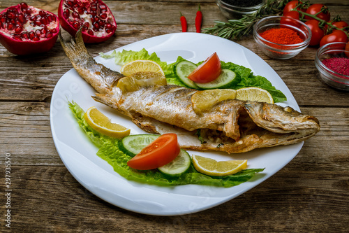 Fried sea bass on wooden table