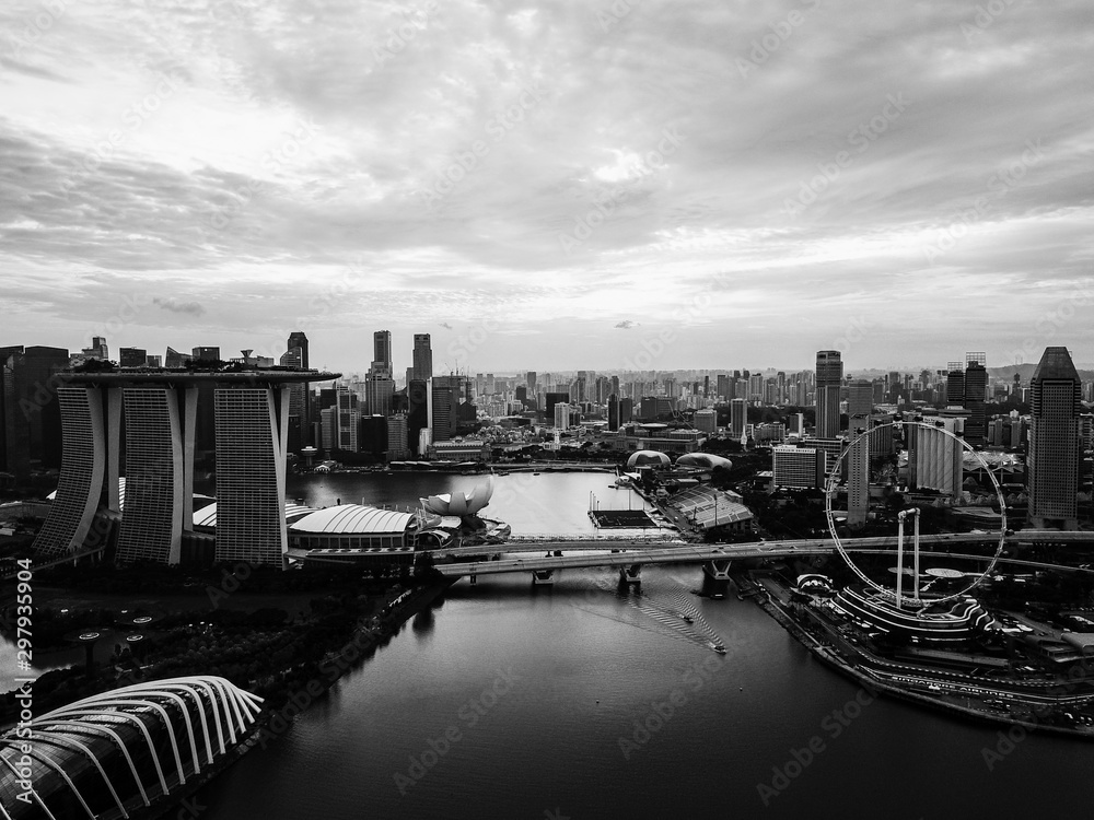 Dramatic Black and White Drone Shot of Singapore Skyline, harbour, Marina Bay and gardens by the bay during Sunset.