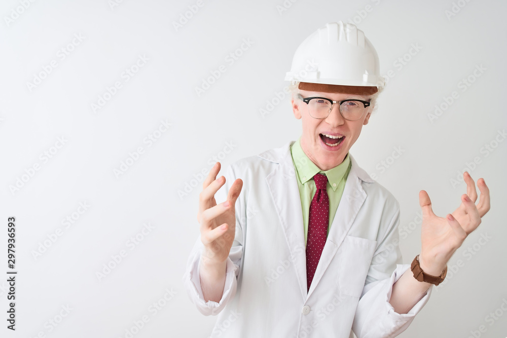 Albino scientist man wearing glasses and helmet standing over isolated white background celebrating crazy and amazed for success with arms raised and open eyes screaming excited. Winner concept Albino scientist man wearing glasses and helmet standing over isolated white background celebrating crazy and amazed for success with arms raised and open eyes screaming excited. Winner concept