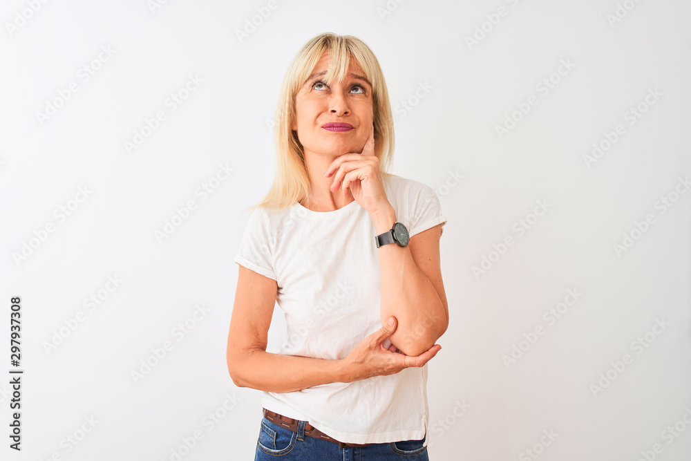 Middle age woman wearing casual t-shirt standing over isolated white background Thinking worried about a question, concerned and nervous with hand on chin Middle age woman wearing casual t-shirt standing over isolated white background Thinking worried about a question, concerned and nervous with hand on chin