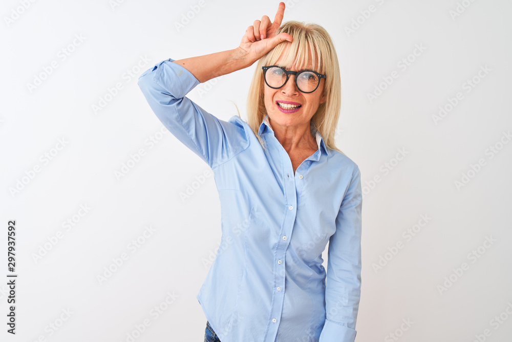 Fototapeta premium Kobieta w średnim wieku na sobie elegancką koszulę i okulary na białym tle na białym tle naśmiewać się z ludzi z palcami na czole robi przegrany gest szyderczy i obraźliwy.