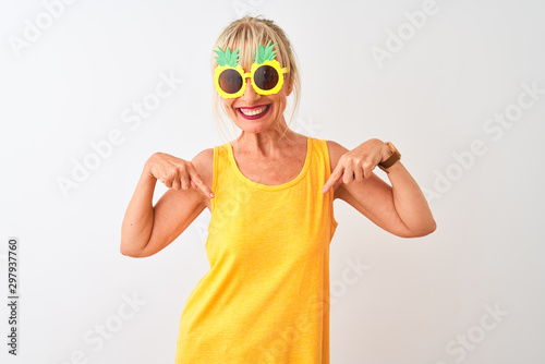 Middle age woman on vacation wearing pineapple sunglasses over isolated white background looking confident with smile on face  pointing oneself with fingers proud and happy.