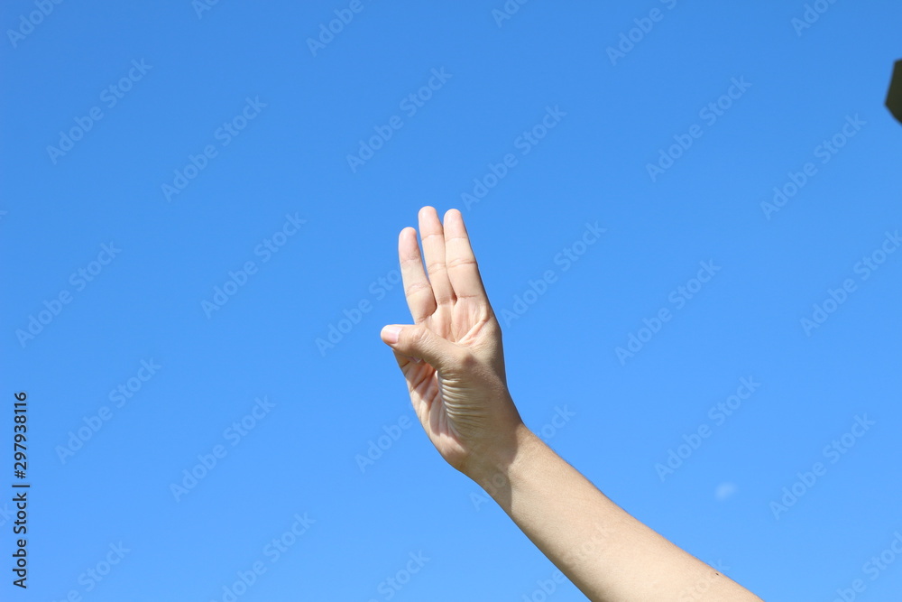 woman hand on blue sky background woman hand on blue sky background