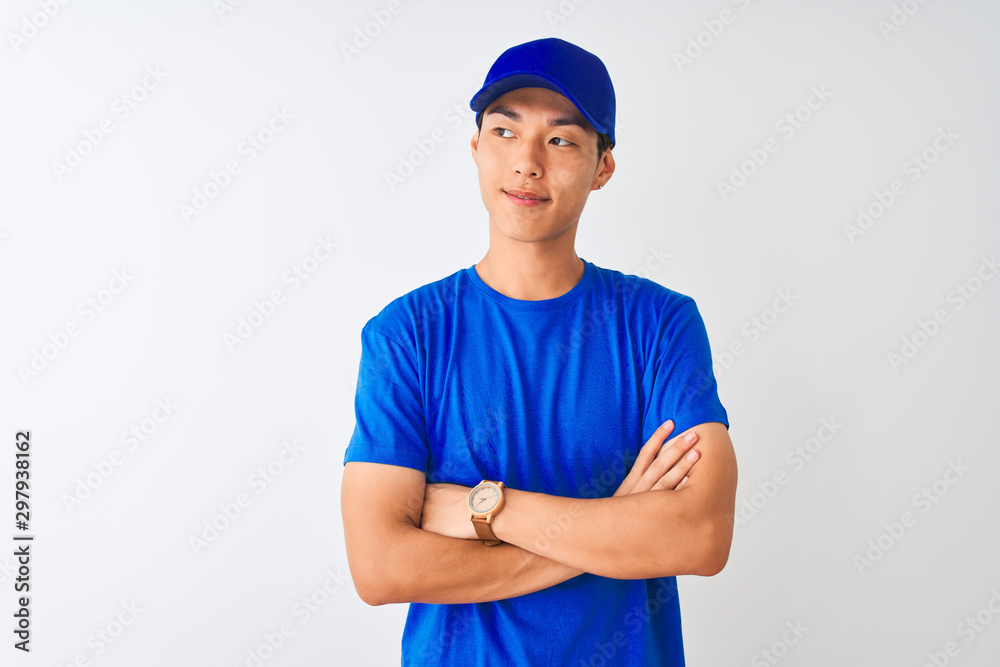 Chinese deliveryman wearing blue t-shirt and cap standing over isolated white background smiling looking to the side and staring away thinking.
