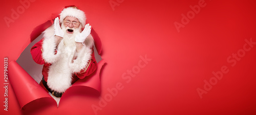 Emotional Santa Claus on the red background. photo