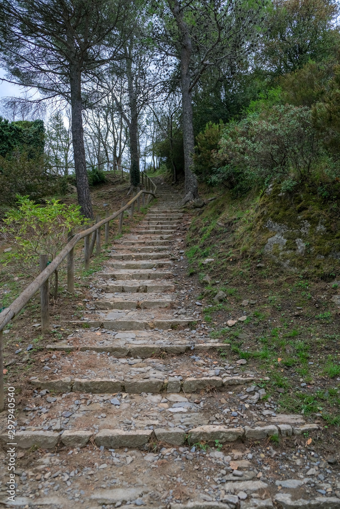 Hiking path leading up to the antique mountain monastery Sant Pere de Rodes. Hiking trails in the sights of Catalunya, Spain. Preservation and popularization of historical monuments. Stones stairs. Hiking path leading up to the antique mountain monastery Sant Pere de Rodes. Hiking trails in the sights of Catalunya, Spain. Preservation and popularization of historical monuments. Stones stairs.