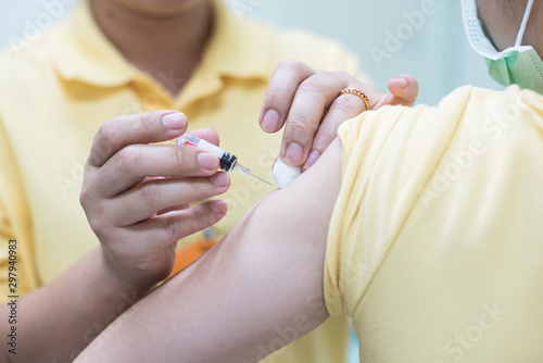 Close up doctor s hand injecting for vaccine in the shoulder woman patient.Nurse using syringe are vaccination to patient for influenza protection.Medication treatment concept.