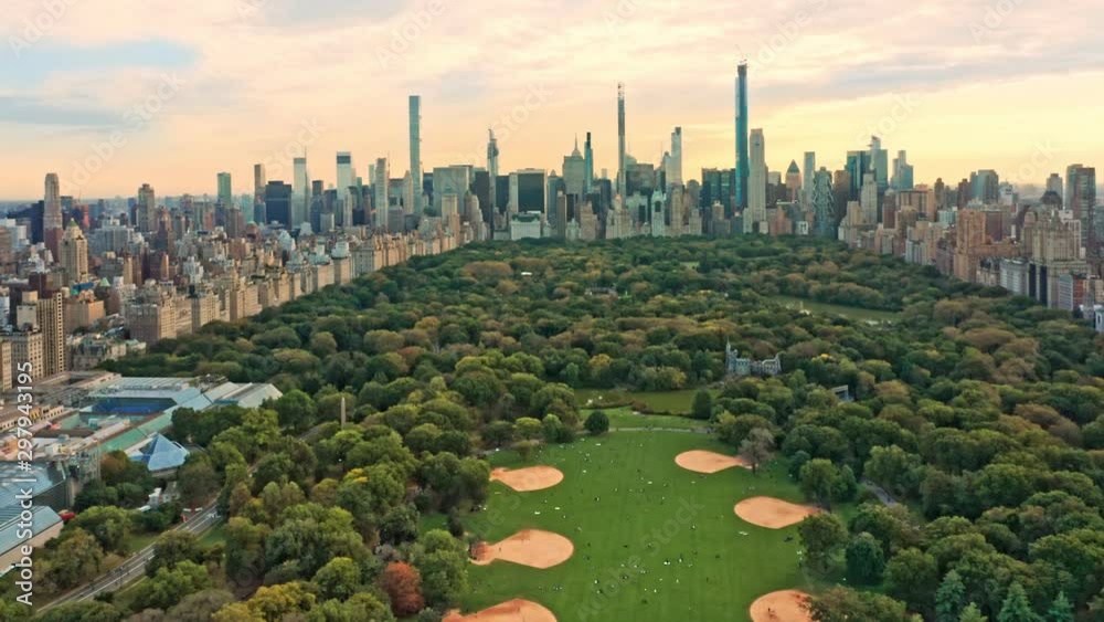 Aerial drone footage of New York midtown skyline at sunset viewed from above Central Park, with slow camera pull back