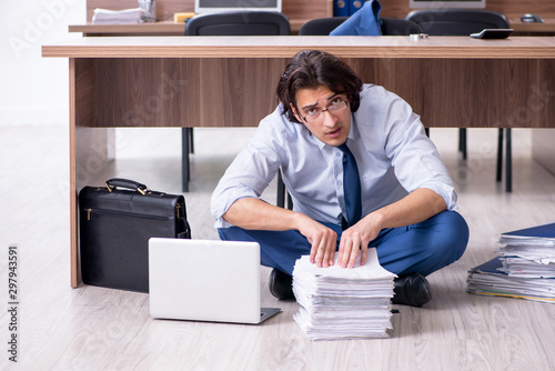 Young male employee and too many work in the office