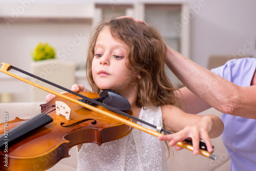 Foto Old lady teaching little girl to play violin
