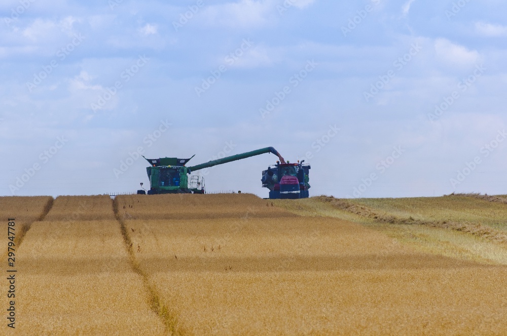 Combine loading harvest into grain cart Combine loading harvest into grain cart