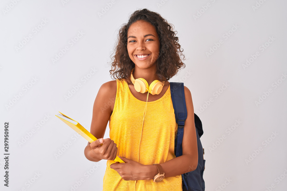 Brazilian student woman wearing backpack holding notebook over isolated white background with a happy face standing and smiling with a confident smile showing teeth - obrazy, fototapety, plakaty 