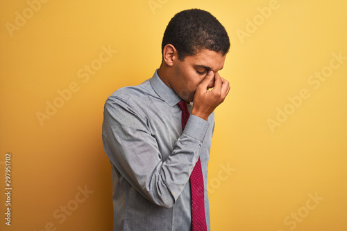 Canvas-taulu Young handsome arab businessman wearing shirt and tie over isolated yellow background tired rubbing nose and eyes feeling fatigue and headache