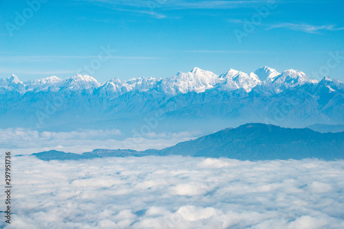 Spectacular view of Himalayas mountain range look through the airplane window. Himalayas is great mountain system of Asia separating the plains of the Indian subcontinent from the Tibetan Plateau.