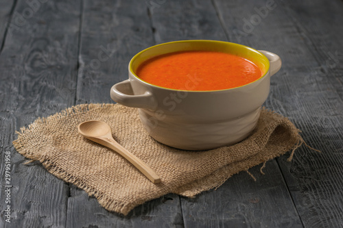 Puree soup with a wooden spoon on a piece of burlap on a wooden table.