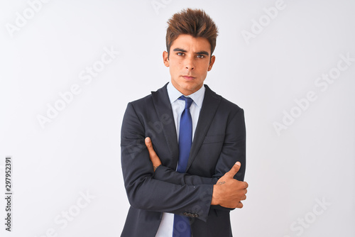 Young handsome businessman wearing suit standing over isolated white background skeptic and nervous, disapproving expression on face with crossed arms. Negative person.