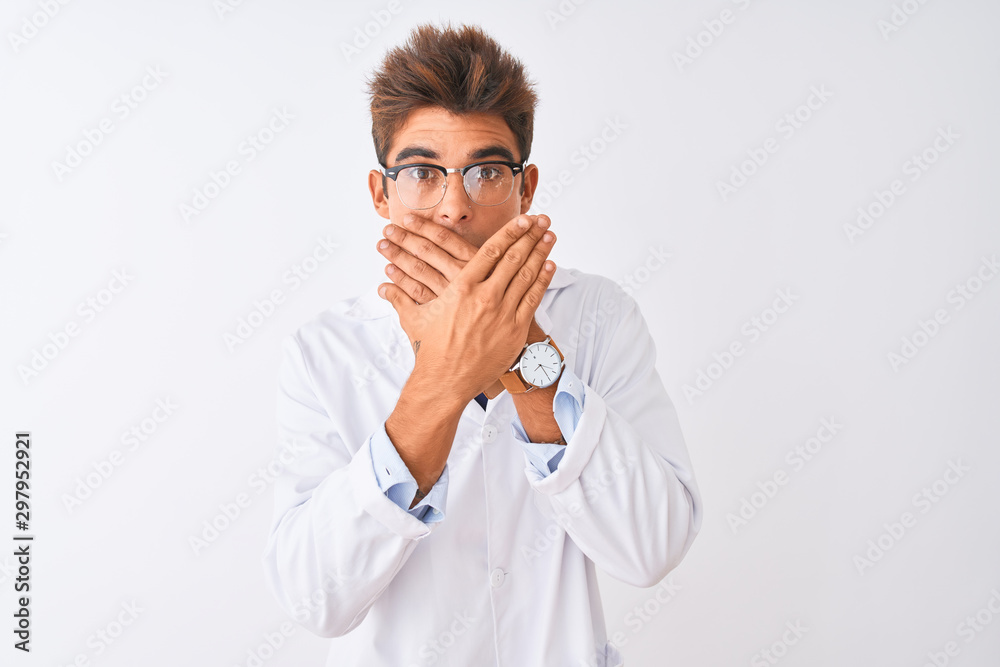 Young handsome sciencist man wearing glasses and coat over isolated white background shocked covering mouth with hands for mistake. Secret concept. Young handsome sciencist man wearing glasses and coat over isolated white background shocked covering mouth with hands for mistake. Secret concept.