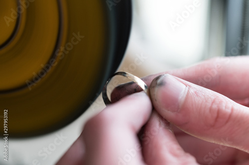 Close-Up Of Jewelry Hands Maker Using Polishing Machine photo