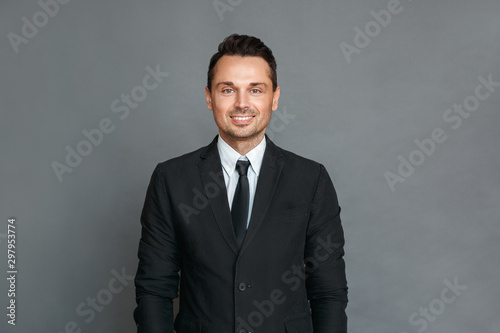 Businessman studio standing isolated on grey looking camera cheerful