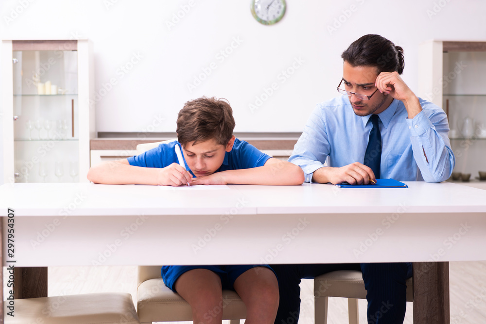 Fototapeta premium Busy father helping his son to prepare for exam