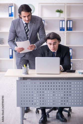 Two young employees working in the office