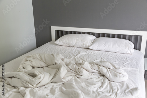 Fototapeta Naklejka Na Ścianę i Meble -  Two white pillow on bed with wrinkle messy blanket in bedroom